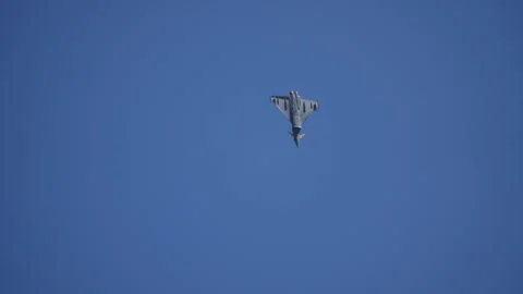 Delta wing fighter jet from below with afterburner in blue sky Stock Footage 336455252