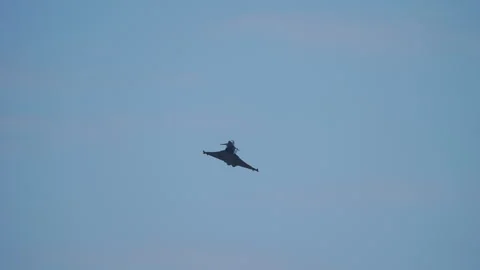 Delta wing fighter jet seen from below in pale grey sky 動画素材 336735013