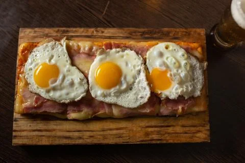 Delucious rectangular pizza with mozarella, bacon and fried eggs Stock Photos