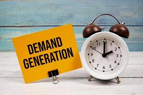 Demand Generation text written on paper card with alarm clock on wooden bac.. Stock Photos