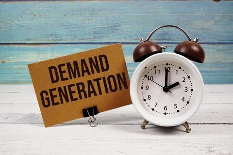Demand Generation text written on paper card with alarm clock on wooden bac.. Stock Photos