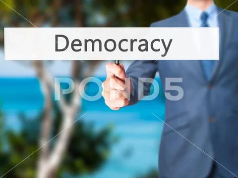 Democracy - Business man showing sign Stock Photos
