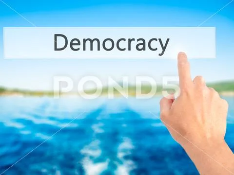 Democracy - Hand pressing a button on blurred background concept Stock Photos