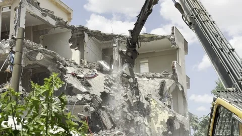 Demolition by a demolition machine. Damaged building. Stock Footage 243317609