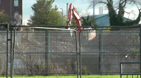 Demolition digger through security fence Stock Footage 14818030