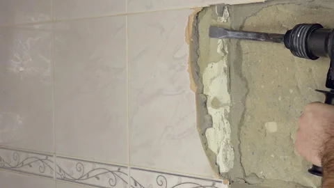 Demolition Hammer Breaking the Tiled Wall Stock Footage 121002323