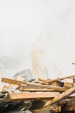 Demolition industry machine taking down walls of old factory building Fotos de archivo