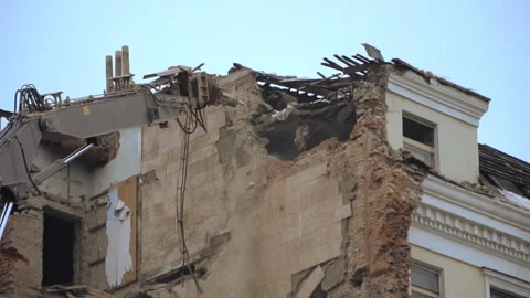Demolition of a multi-storey building with hydraulic shears, for future devel Stock Footage 99748143