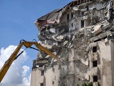 Demolition work is taking place on a building with heavy machinery removing.. Stock Photos