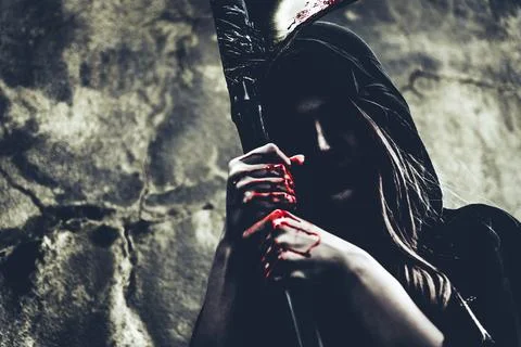 Demon witch with reaper standing in front of grunge wall background. Hallow.. Stock Photos