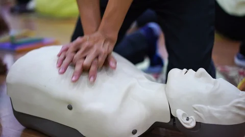 Demonstrating chest compressions on CPR doll in the class, CPR training medical  Stock Footage 128411221