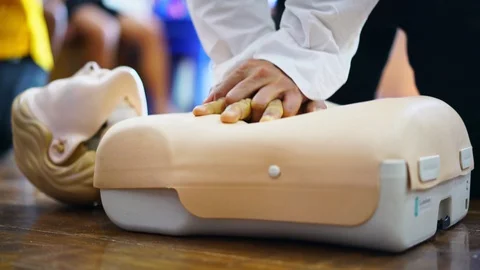 Demonstrating chest compressions on CPR doll in the class, CPR training medical  Stock Footage 128411236