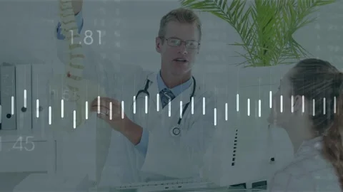 Demonstrating doctor in white coat pointing spine model toward patient in Stock Footage 333277805