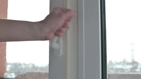 Demonstrating the process of opening and securing a window. Broken plastic door Stockbeeldmateriaal 337111495