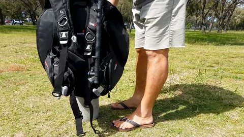 Demonstrating the process of setting up scuba equipment Stock Footage 107172760