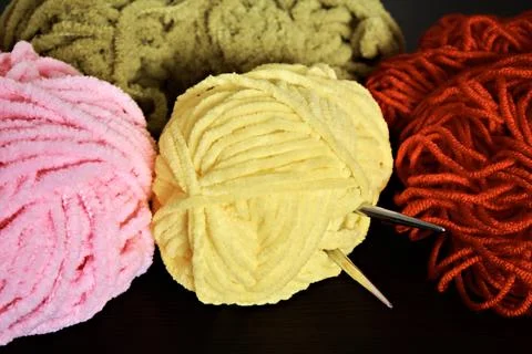 Demonstration of colored knitting threads and knitting needles sticking out o Stock Photos