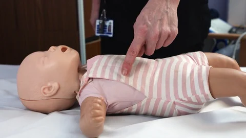 Demonstration of CPR technique for a baby Stock Footage 87460033