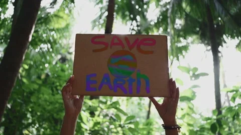 Demonstration of hands holding a rainbow colored "Save the Earth" Stock Footage 148082300