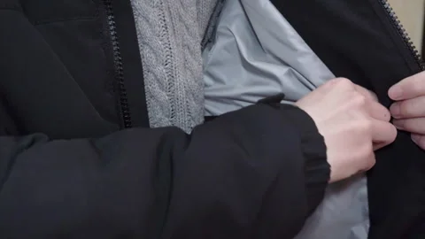 Demonstration of the inner pocket and lining of a winter jacket Stock Footage 334646694
