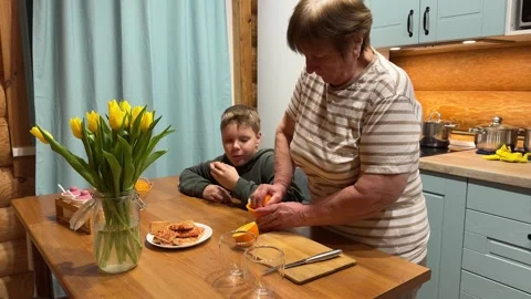 A demonstration of juice extraction, knowledgeable grandmother and grandson Stock Footage 309534645