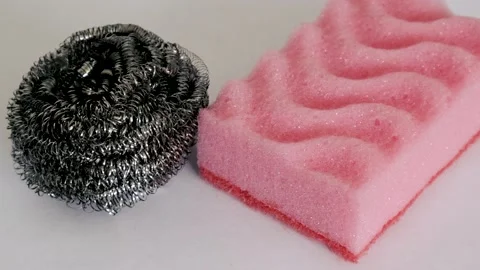 Demonstration of kitchen care products: kitchen and metal sponge on a white back Stock Footage 233353307