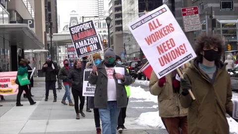 Demonstrators carry placards supporting a union for Amazon warehouse workers in Video stock 317615566