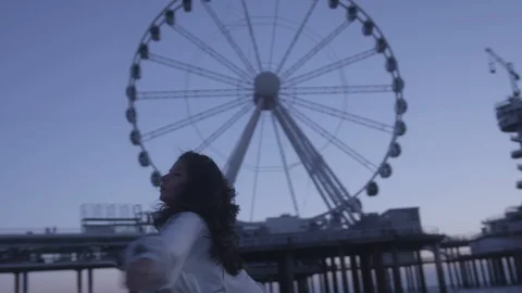 Den Haag Beach Package 10 | woman playful spinning beach next to panorama wheel Video stock 116663873