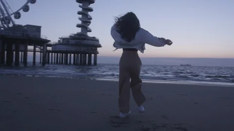 Den Haag Beach Package 13 | woman playful spinning in beach panorama wheel Stock Footage 116185046