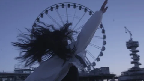 Den Haag Beach Package 15 | woman playful spinning beach next to panorama wheel Stock Footage 116185893