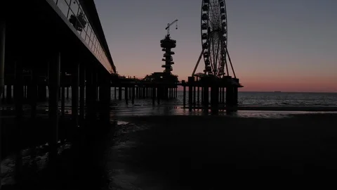 Den Haag Beach Package 23 | drone flying under bridge reveals beach carousel Video stock 116204309
