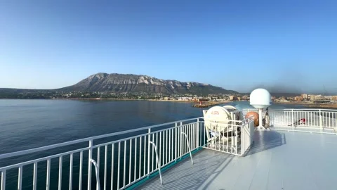 Denia, Spain. 07.07.2025. Ship leaving port with mountain and coastline view Stock Footage 318735864