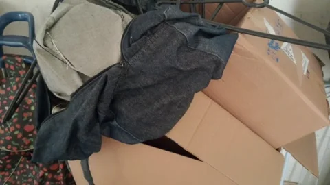 Denim bag and cardboard boxes in messy storage room video motion Stock Footage 339349188