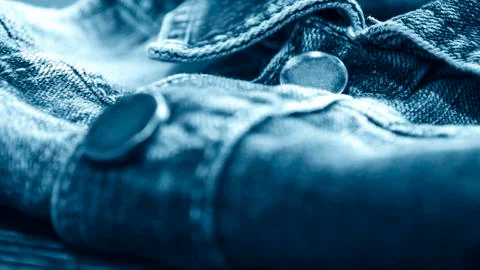 Denim clothes lying on the table with the glasses. Blue jeans wi Stock Photos