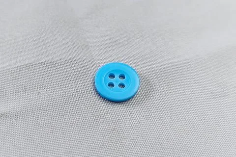 A denim colored button on the fabric texture Stock Photos