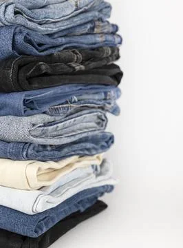Denim pants stack on white background. Shopping concept. Stock Photos