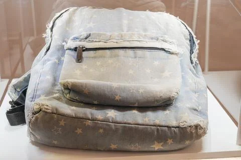 Denim patchwork backpack, American flag design, display case, museum setting, Foto stock