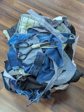 Denim Scraps Workshop. An Array Of Distressed Denim Remnants Alongside Rule.. Stock Photos