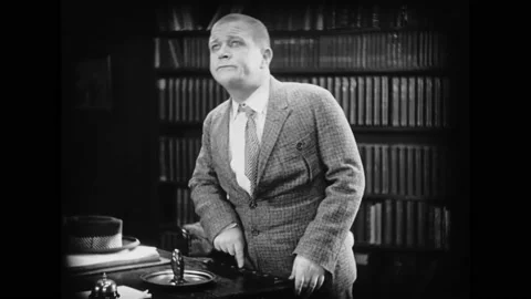 DENMARK - 1929 - in this silent comedy, a man pushes a button on a desk, Stock Footage 279780440