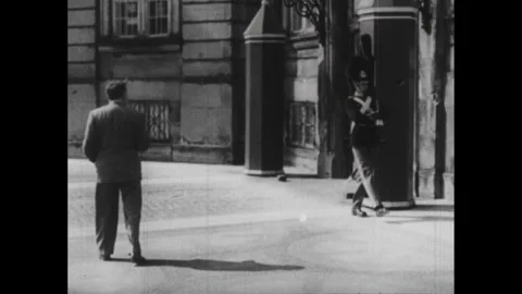 DENMARK 1940s: Man walks in front of Danish government building where guards Vídeos de archivo 253354755