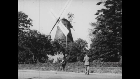 DENMARK 1940s: Pathway over moat to castle. Man walks towards windmill. Blades Vidéo 253354686