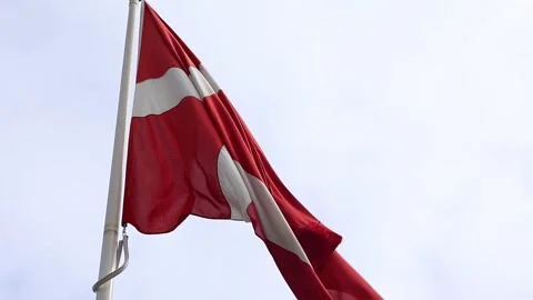 Denmark's national flag, the Dannebrog, waving slowly in the wind against a Stock Footage 345758668
