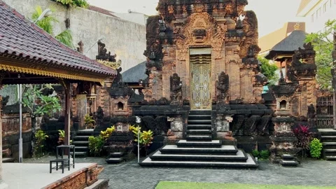 Denpasar Bali temple courtyard with stone carvings, carved wooden door and 스톡 동영상 317096364