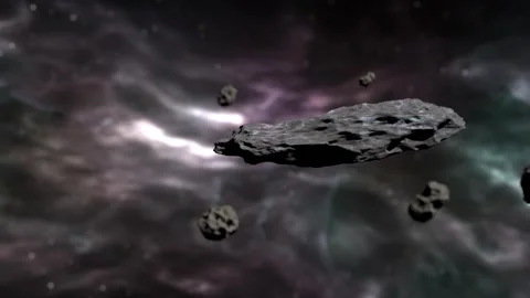 Dense asteroid field floating in deep space with colorful nebula background Stock Footage 317838064