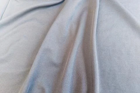 A dense background backdrop texture of smooth silver gray spandex nylon fabri Stock Photos