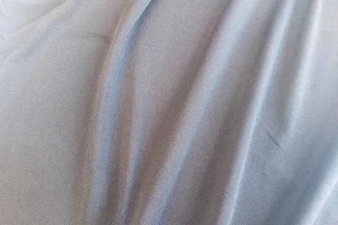 A dense background backdrop texture of smooth silver gray spandex nylon fab.. Stock Photos