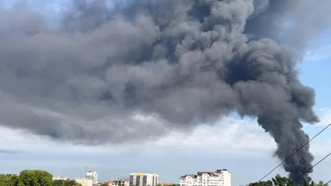Dense black smoke rising dramatically over urban skyline Stock Footage 286758924