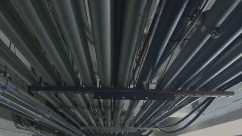Dense Bundle of Industrial Metal Conduits and Pipes on Ceiling 库存影片 336335026