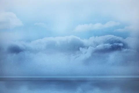 Dense cloud bank is spanning calm water in flat design, highlighting reflective Stock Photos