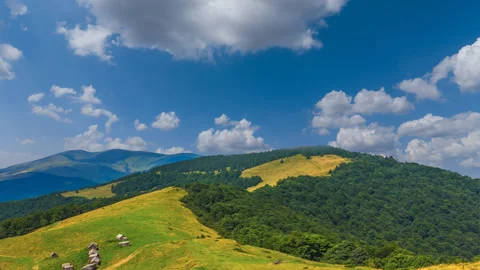 Dense clouds above a green mountain chains time lapse scene Stock Footage 309742884