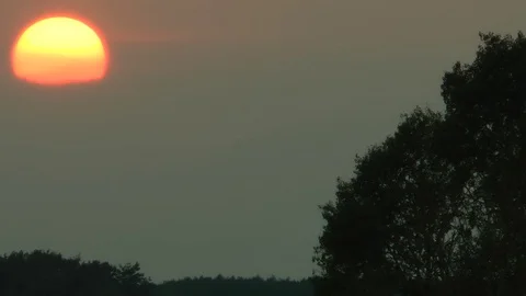 Dense clouds and atmospheric haze have hidden the sun during a sunset. Vidéo 70311993